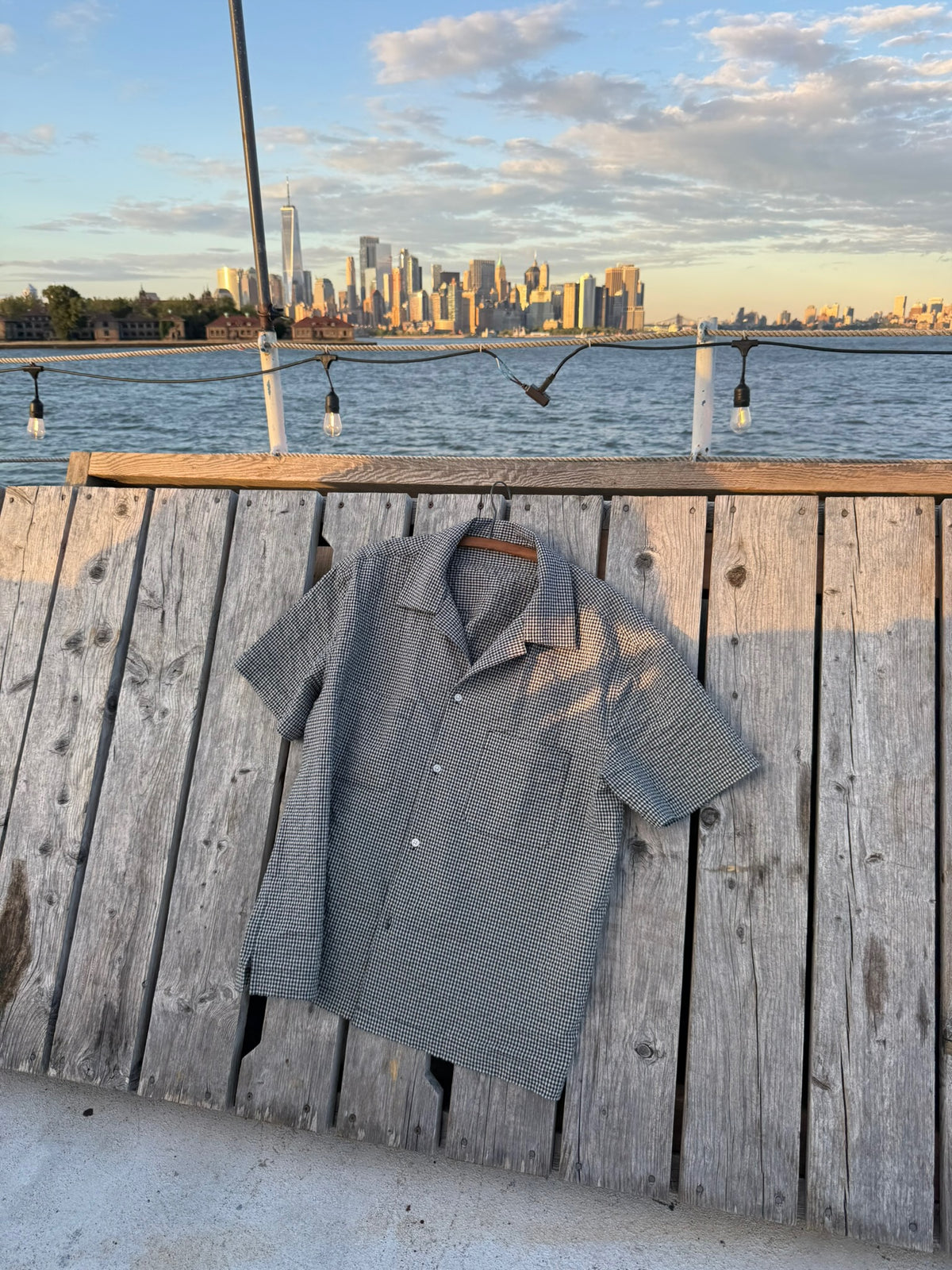 NYC Shirt laid flat on the deck with the Manhattan skyline behind